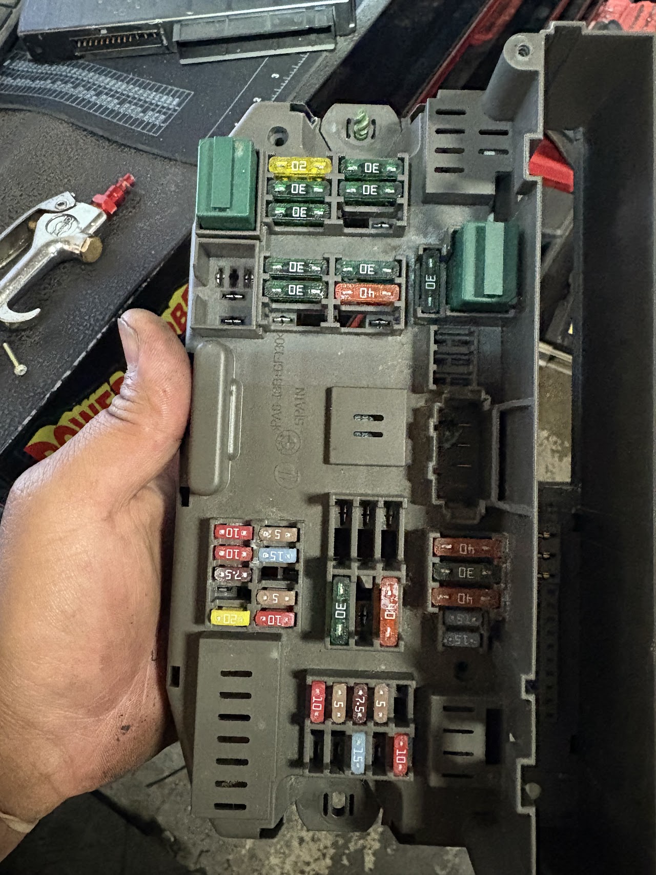 Automotive fuse and relay box being inspected during electrical work